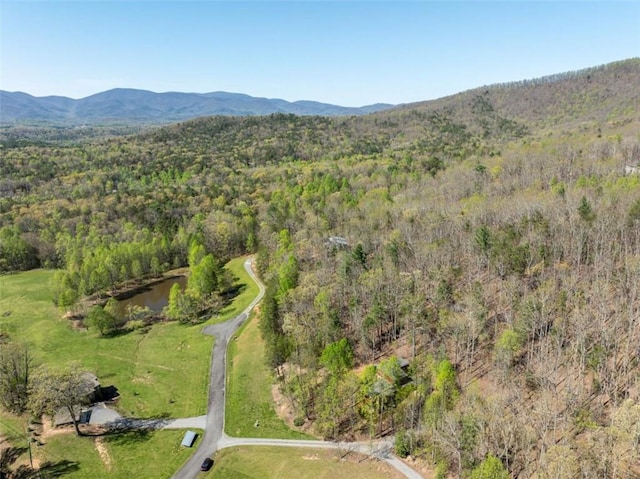 birds eye view of property featuring a mountain view and a wooded view