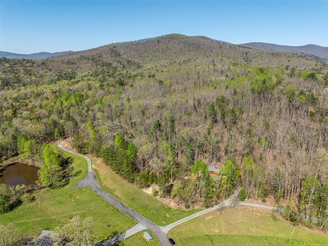 birds eye view of property with a wooded view and a mountain view