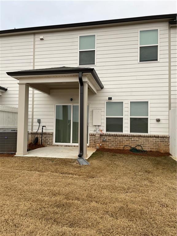 rear view of house featuring a yard and a patio