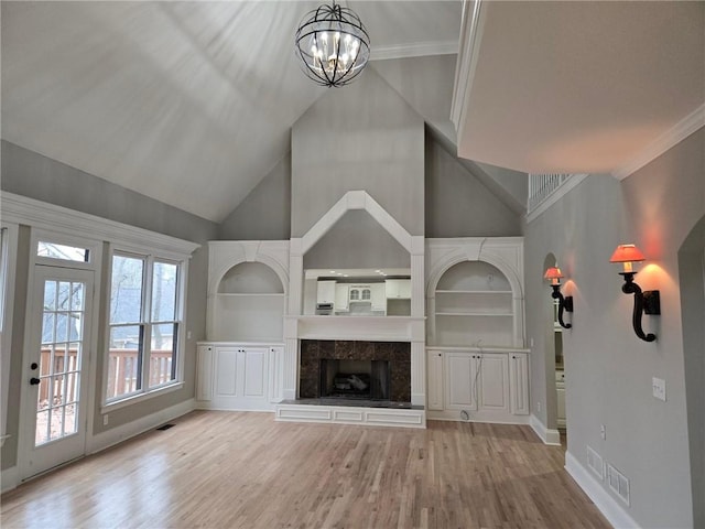 7910 Tintern Trce, Duluth, GA 30097 - unfurnished living room with baseboards, an inviting chandelier, built in shelves, and light wood-style flooring