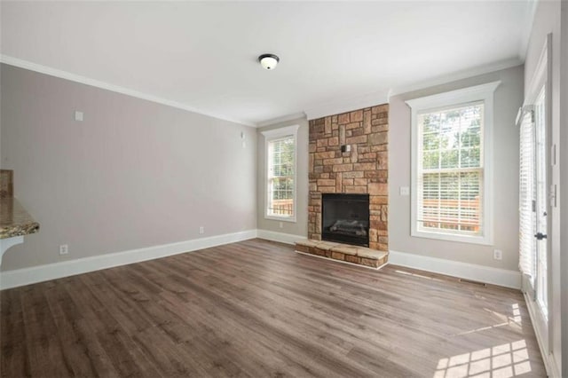 5737 Russell Ct, Douglasville, GA 30135 - unfurnished living room with crown molding, a stone fireplace, plenty of natural light, and wood finished floors