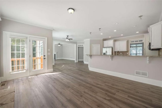 5737 Russell Ct, Douglasville, GA 30135 - unfurnished living room featuring visible vents, baseboards, a ceiling fan, crown molding, and wood finished floors