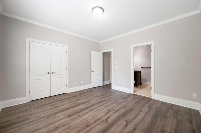 5737 Russell Ct, Douglasville, GA 30135 - unfurnished bedroom with a closet, baseboards, ornamental molding, connected bathroom, and wood finished floors