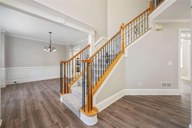 5737 Russell Ct, Douglasville, GA 30135 - stairway with a chandelier, crown molding, wood finished floors, and visible vents