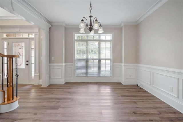 5737 Russell Ct, Douglasville, GA 30135 - unfurnished dining area featuring ornamental molding, an inviting chandelier, a wainscoted wall, and wood finished floors
