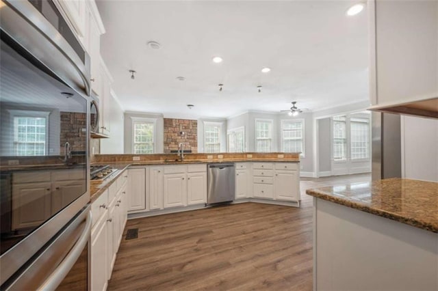5737 Russell Ct, Douglasville, GA 30135 - kitchen featuring recessed lighting, a peninsula, white cabinetry, appliances with stainless steel finishes, and wood finished floors