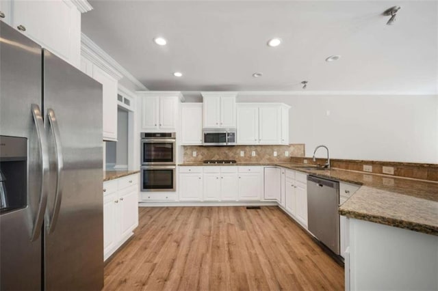 5737 Russell Ct, Douglasville, GA 30135 - kitchen with a sink, ornamental molding, white cabinets, and appliances with stainless steel finishes