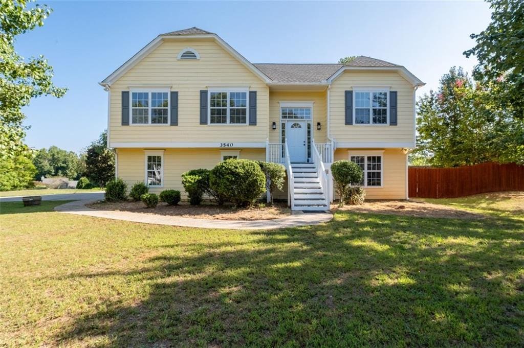 split foyer home with fence and a front lawn