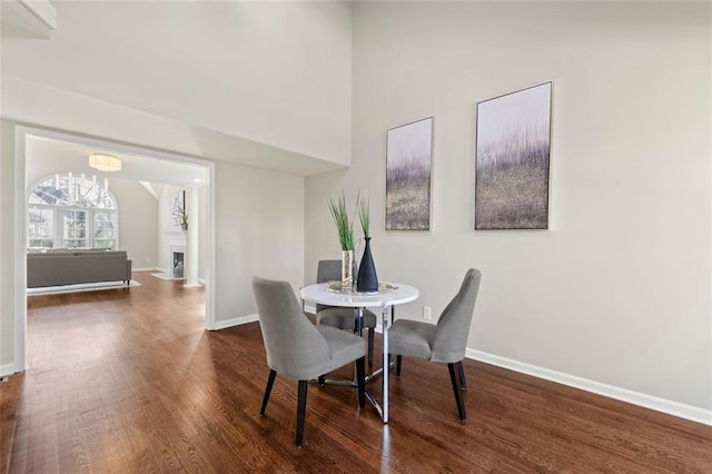 dining space featuring an inviting chandelier, baseboards, and wood finished floors