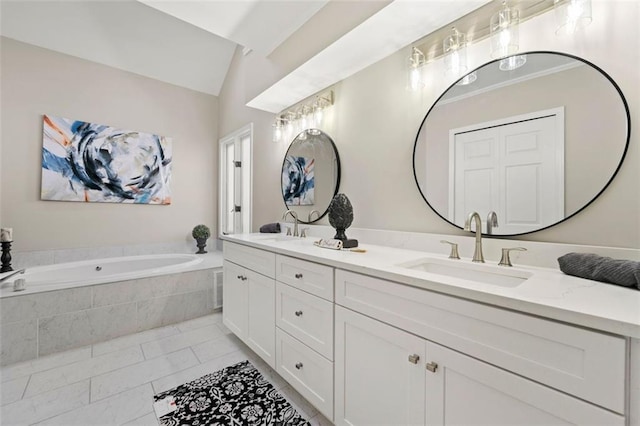 full bathroom featuring a sink, a garden tub, double vanity, and vaulted ceiling