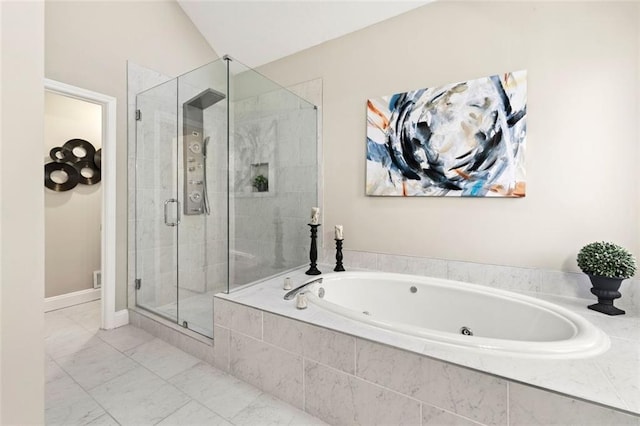 bathroom featuring a bath, a stall shower, and marble finish floor