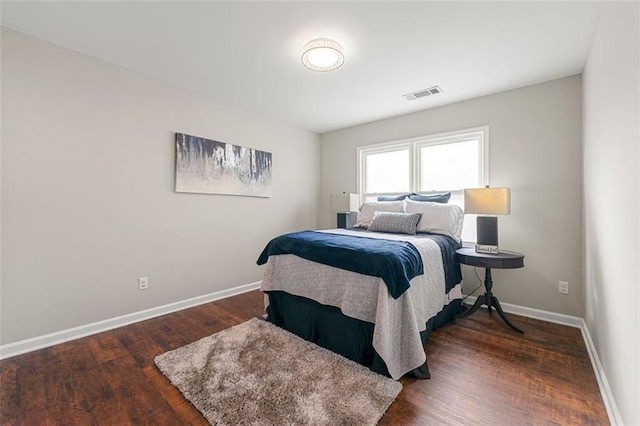 bedroom with dark wood finished floors, baseboards, and visible vents