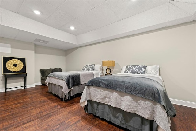 bedroom featuring recessed lighting, wood finished floors, baseboards, and a drop ceiling