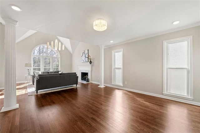 unfurnished living room with a fireplace, wood finished floors, baseboards, and decorative columns