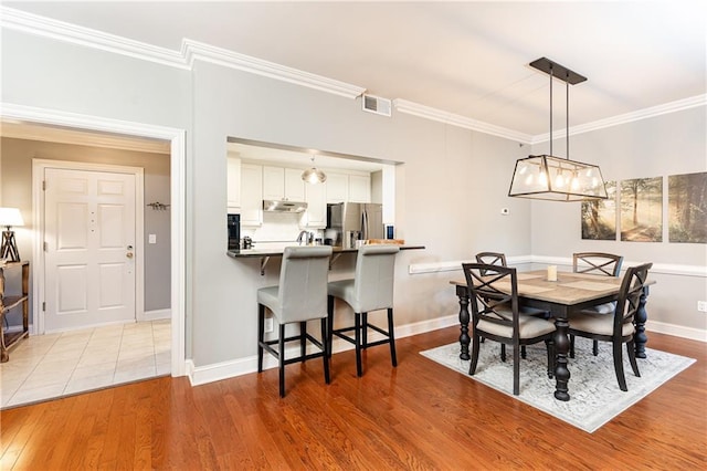 211 Colonial Homes Dr NW Unit 2501, Atlanta, GA 30309 - dining space featuring crown molding, wood finished floors, and baseboards