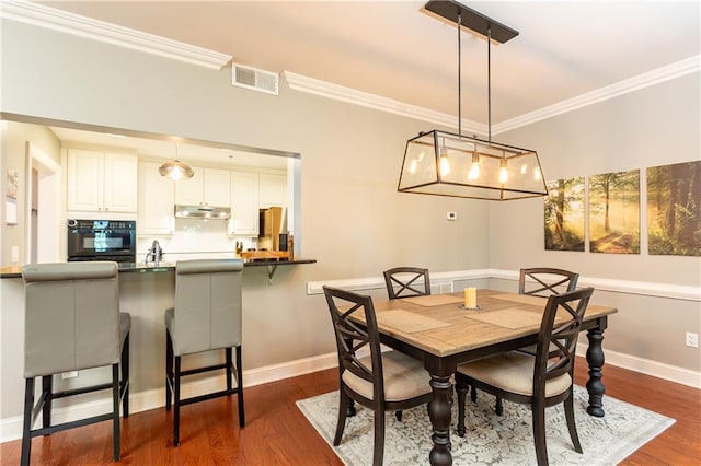 211 Colonial Homes Dr NW Unit 2501, Atlanta, GA 30309 - dining area featuring dark wood-style floors, crown molding, and baseboards