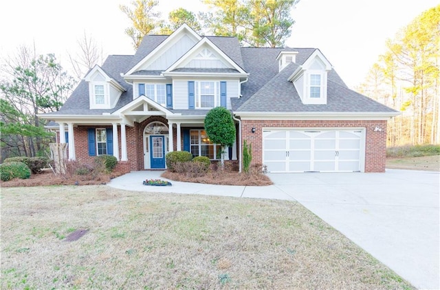 craftsman-style home with driveway, roof with shingles, an attached garage, a front lawn, and brick siding