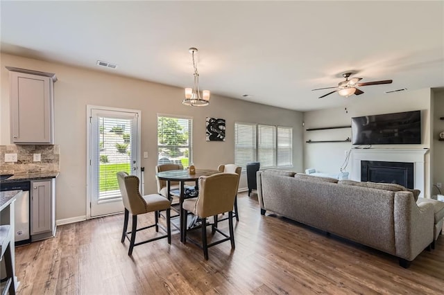 2486 Bear Mountain St, Lithonia, GA 30058 - dining area featuring a fireplace, wood finished floors, ceiling fan, and a chandelier