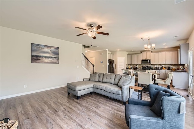 2486 Bear Mountain St, Lithonia, GA 30058 - living room featuring stairs, light wood-style floors, a ceiling fan, recessed lighting, and a chandelier