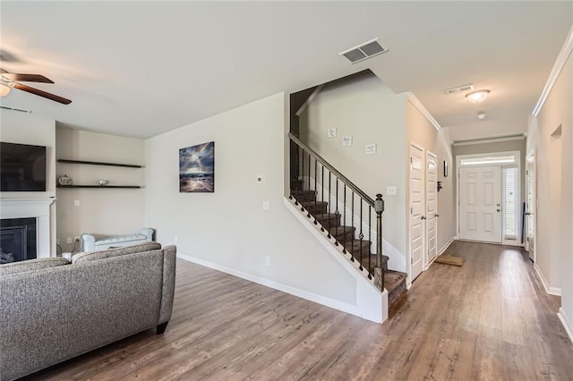 2486 Bear Mountain St, Lithonia, GA 30058 - living room with wood finished floors, a ceiling fan, stairway, and a glass covered fireplace