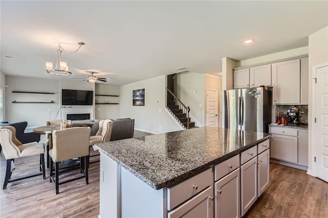 2486 Bear Mountain St, Lithonia, GA 30058 - kitchen featuring freestanding refrigerator, gray cabinetry, ceiling fan, wood finished floors, and a fireplace