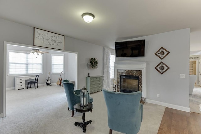 living room featuring ceiling fan, hardwood / wood-style floors, and a premium fireplace