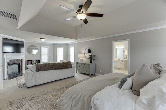 carpeted bedroom featuring connected bathroom, ornamental molding, ceiling fan, and a fireplace