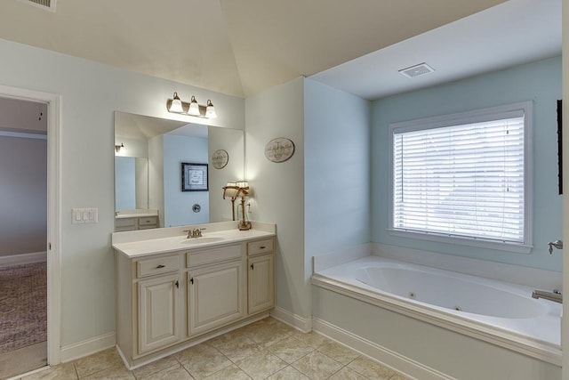 bathroom featuring vanity, a tub to relax in, tile patterned floors, and vaulted ceiling