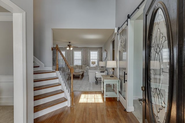 entryway featuring ceiling fan, a barn door, and light hardwood / wood-style floors