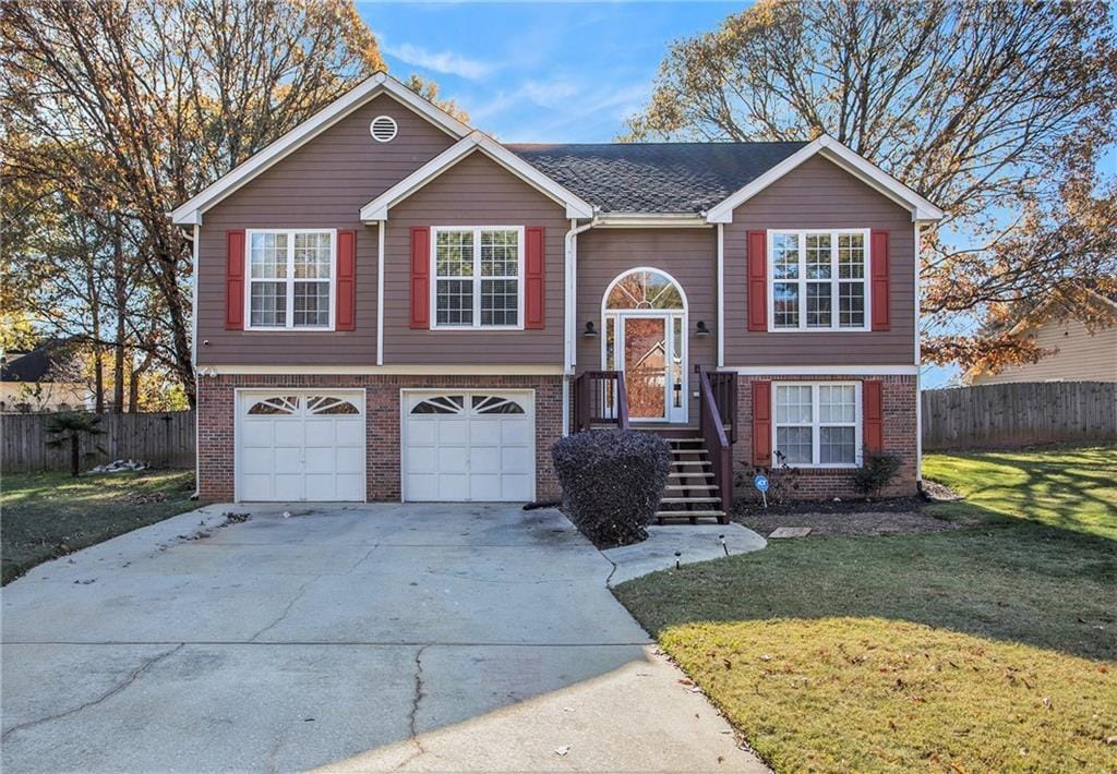 raised ranch with a front yard and a garage