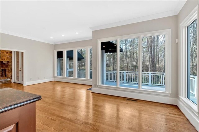 unfurnished living room featuring crown molding, light wood-style floors, baseboards, visible vents, and recessed lighting