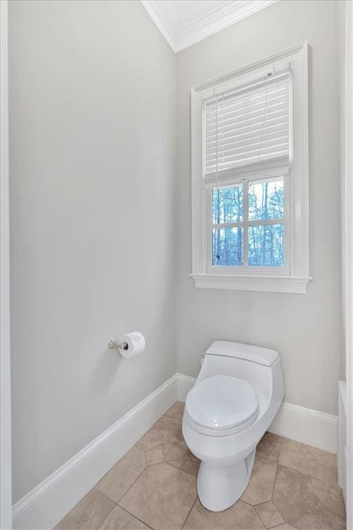 bathroom with tile patterned floors, baseboards, ornamental molding, and toilet