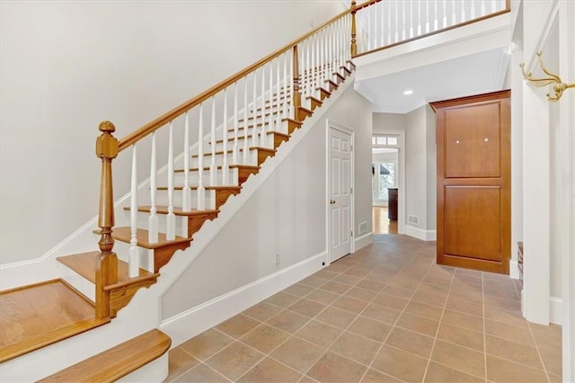 stairs featuring baseboards, ornamental molding, tile patterned flooring, and recessed lighting