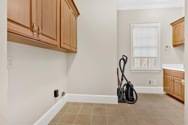 laundry area featuring baseboards, crown molding, visible vents, and light tile patterned floors