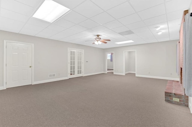 interior space featuring dark colored carpet, a paneled ceiling, visible vents, and baseboards