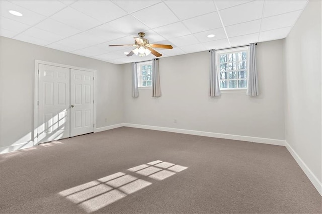 interior space featuring baseboards and a drop ceiling