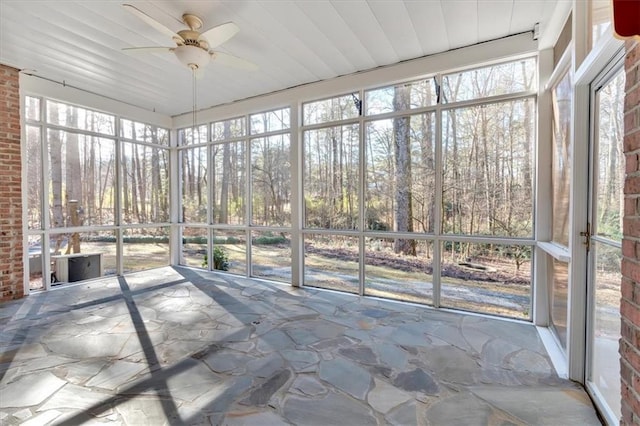 unfurnished sunroom featuring a wealth of natural light and ceiling fan