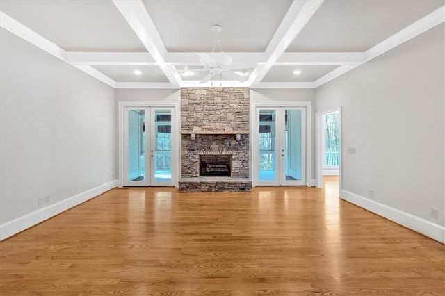 unfurnished living room with beamed ceiling, coffered ceiling, baseboards, and french doors