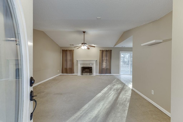 unfurnished living room with ceiling fan, light carpet, and vaulted ceiling