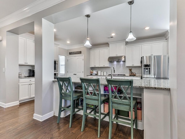 kitchen featuring white cabinetry, stainless steel refrigerator with ice dispenser, under cabinet range hood, and ornamental molding