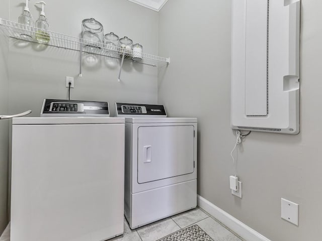 laundry area featuring light tile patterned floors, baseboards, laundry area, and washing machine and clothes dryer