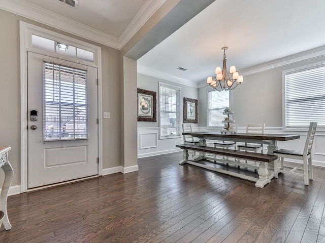 dining area with visible vents, an inviting chandelier, hardwood / wood-style floors, and crown molding