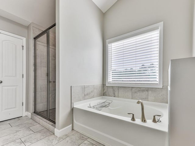 full bath featuring a bath, a shower stall, and baseboards