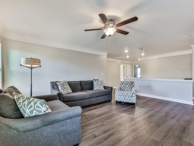 living area featuring baseboards, a ceiling fan, dark wood-style floors, and crown molding