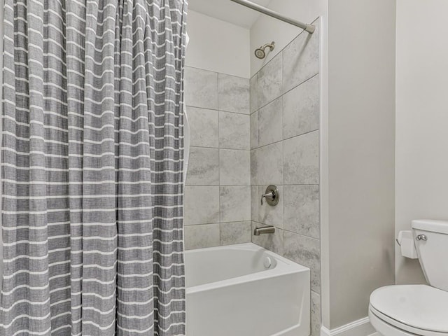 bathroom with baseboards, toilet, and shower / tub combo