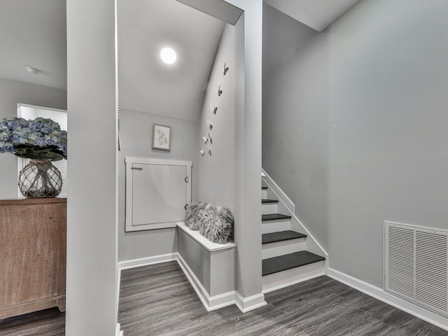 stairs with wood finished floors, visible vents, and baseboards