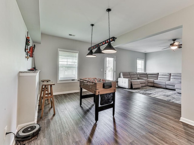 playroom with visible vents, baseboards, dark wood-type flooring, and ceiling fan