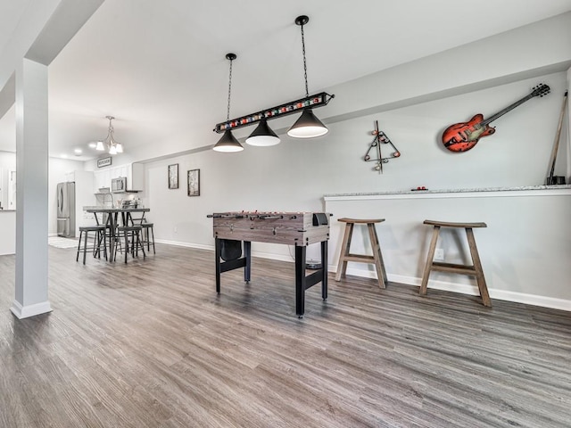 rec room with wood finished floors and baseboards