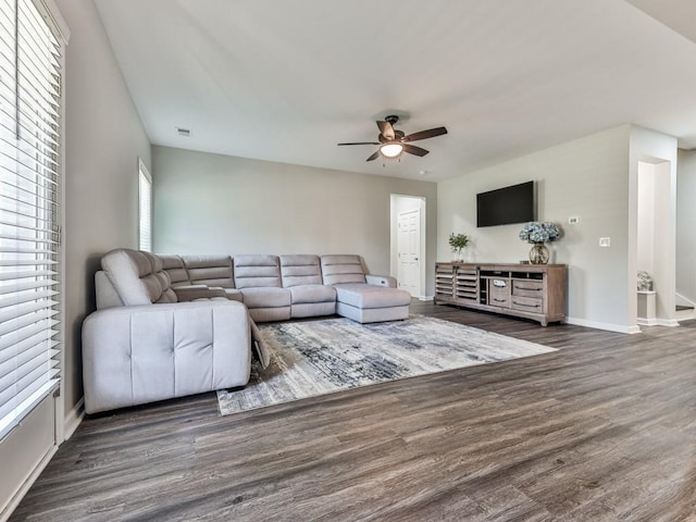 living area with visible vents, wood finished floors, baseboards, and ceiling fan