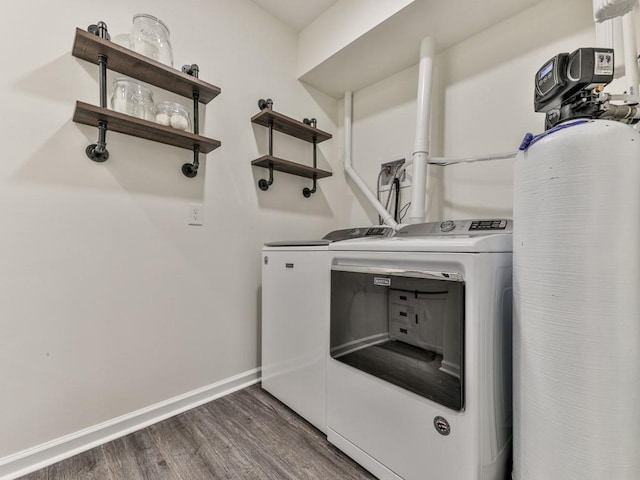 laundry room with laundry area, washing machine and dryer, baseboards, and wood finished floors